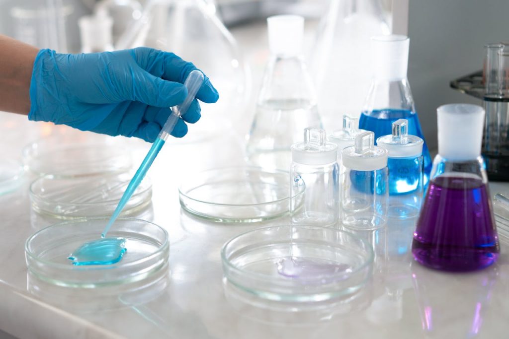 zipwp-image-9628798 Chemist Hand in Glove over Table at Laboratory